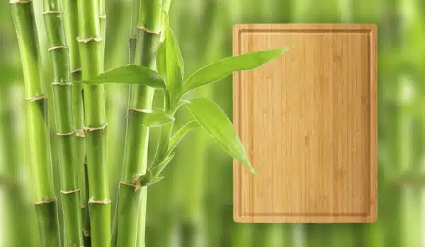 A vibrant image of bamboo stalks alongside a bamboo cutting board, highlighting the sustainable and eco-friendly qualities of bamboo cutting boards for kitchen use.